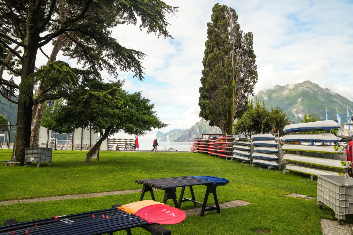 Kayak in rastrelliera e pagaie appoggiate sul prato del centro Vasco Renna a Torbole